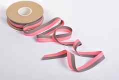 粉红色的灰色的棉花丝带卷纺织品筒子身材魁梧的磁带绳子石灰带子旋度白色背景