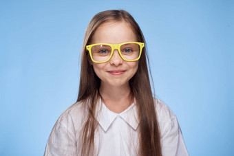 快乐的女孩白色衬衫眼镜工作室蓝色的背景有趣的童年