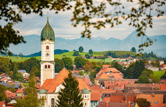美丽的舒适的小巴伐利亚村德国欧洲教堂房子前景多云的天空山背景