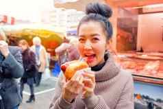 年轻的女人吃热狗街食物德国