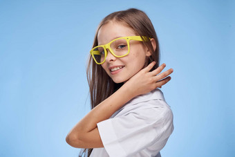 快乐的女孩白色衬衫眼镜工作室蓝色的背景有趣的童年