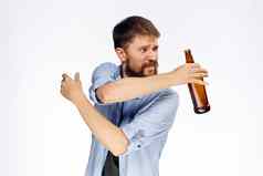 喝醉了有胡子的男人。瓶啤酒手一边蓝色的衬衫光背景