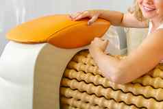 女人使按摩手卷按摩机形状数字皮肤护理身体护理概念现代放松按摩设备