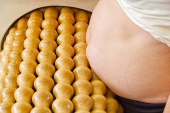 怀孕了女人使按摩胃卷按摩机形状数字皮肤护理概念现代放松按摩设备