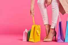 购物袋女脚鞋子购物狂粉红色的背景