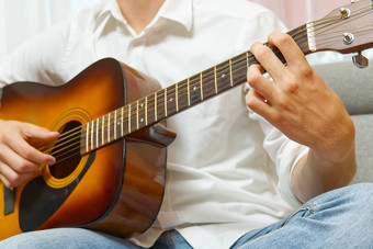 年轻的男孩玩吉他特写镜头男人。手玩经典吉他少年学习玩吉他