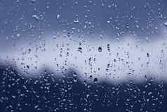 湿窗口多雨的秋天天气水滴玻璃蓝色的健美的