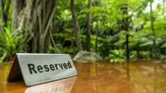 保留标志使不锈钢钢板层压木表格餐厅树森林背景