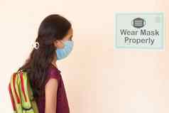 年轻的女孩学生调整面具穿面具正确请注意教室墙进入类保护冠状病毒科维德感染