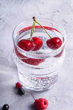 新鲜的冷闪闪发光的水喝樱桃树莓醋栗
