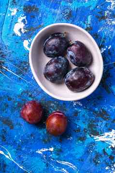 新鲜的甜蜜的李子水果白色碗蓝色的背景