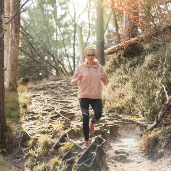 活跃的运动女人听<strong>音乐</strong>运行秋天秋天森林女跑步者<strong>培训</strong>户外健康的生活方式图像年轻的高加索人女人慢跑