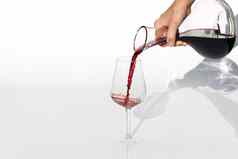 品酒 师倒红色的酒玻璃水瓶葡萄酒杯白色背景