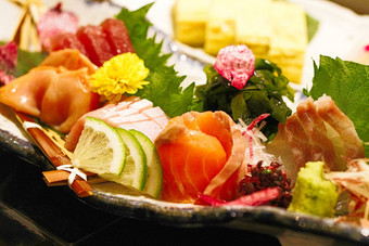 正确的真实的生鱼片菜板独特的日本日本食物风格生鱼绿色叶子电影颜色电影风格耀斑光