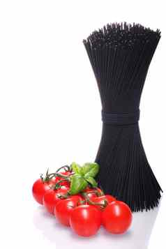 黑色的意大利面巴塞尔协议叶子红色的番茄白色背景