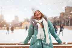 美丽的可爱的中年女孩卷曲的头发温暖的冬天夹克站冰溜冰场背景小镇广场