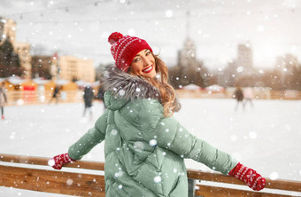 美丽的可爱的中年女孩卷曲的头发温暖的冬天夹克站冰溜冰场背景小镇广场