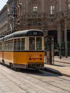 黄色的有轨电车通过街道城市米兰