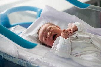 美丽的新生儿婴儿男孩铺设婴儿床产前医院