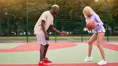 篮球非洲式发型美国男人。朋友培训高加索人女人多民族的友谊非洲式发型的家伙教练教学女