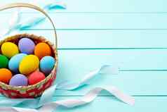 复活节一天鸡蛋装饰色彩斑斓的鸡蛋蓝色的木表格