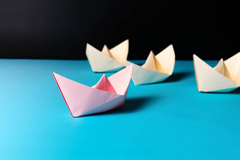 领导概念粉红色的纸船引领黄色的船<strong>团队成员</strong>