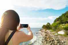 旅行生活方式女旅游采取照片美丽的海滩