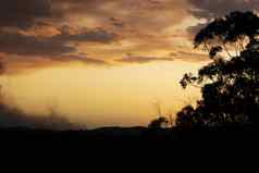 红色的日落引起的森林大火烟蓝色的山澳大利亚