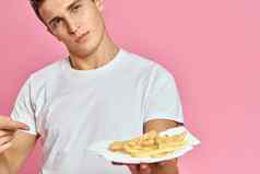 男人。法国薯条纸盒子粉红色的背景卡路里快食物肖像粉红色的背景