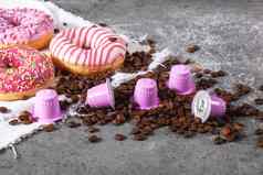 表示粉红色的塑料胶囊箔咖啡豆子甜蜜的甜甜圈
