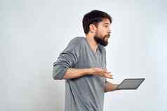 男人。平板电脑手互联网技术沟通灰色的夹克光背景