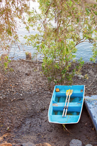 小蓝色的划艇黄色的桨泥泞的河银行