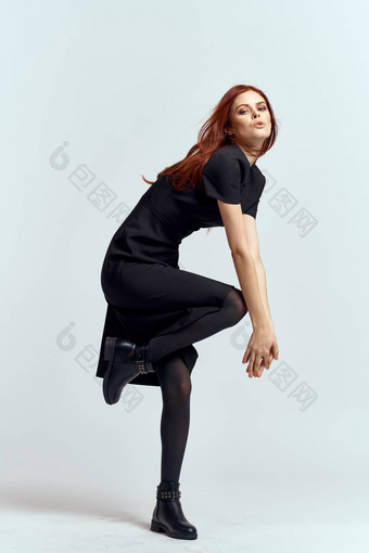 女人站腿光背景完整的增长黑色的衣服