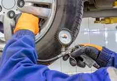 特写镜头机械师修复服务站检查轮胎压力计