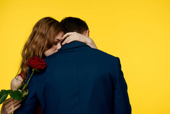 情人男人。女人红色的玫瑰手拥抱黄色的背景浪漫的关系爱家庭