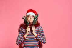 女人圣诞节树分支机构手红色的俗丽的节日他粉红色的背景裁剪视图