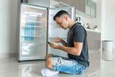 年轻的的家伙订单食物智能手机空冰箱食物食物交付服务广告