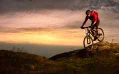 骑自行车的人红色的骑自行车秋天岩石小道日落极端的体育运动复古骑自行车概念