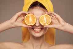 女人黄色的毛巾头橙子特写镜头米色背景