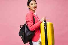 女人旅游手提箱行李乘客旅行粉红色的背景