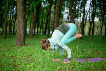 薄浅黑肤色的女人女孩起重机锻炼巴卡萨纳构成夏天公园绿色<strong>郁郁葱葱</strong>的森林背景女人练习瑜伽席
