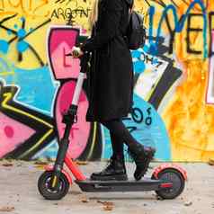 时尚的十几岁的女孩骑公共租赁电踏板车城市城市环境秋天环保现代公共城市运输卢布尔雅那