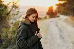 漂亮的女人温暖的夹克自然新鲜的空气旅行太阳