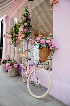 粉红色的自行车包围人工花粉红色的蛋糕商店
