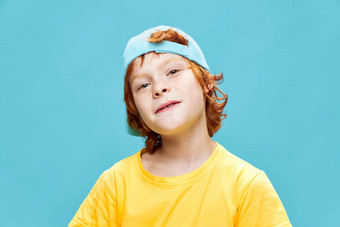 红发男孩蓝色的帽黄色的t恤裁剪视图
