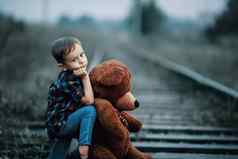 被遗弃的无家可归的人孩子孤儿孤独的男孩拥抱塞玩具坐在跟踪可悲的是相机