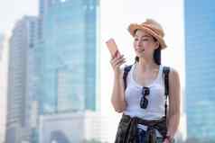 美丽的亚洲旅游女人移动电话搜索位置具有里程碑意义的假期旅行夏天