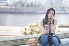 美丽的亚洲只有旅游女人放松享受听音乐智能手机城市城市市中心