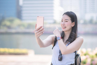 美丽的亚洲女人享受<strong>视频</strong>调用技术智能手机<strong>城市城市</strong>市中心