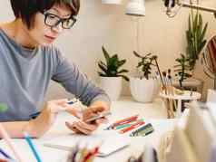 女人短头发减少画笔记本智能手机平静的爱好抗应激休闲艺术家工作舒适的工作场所